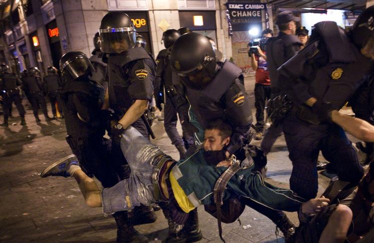 Protest. En spansk demonstrant bliver slæbt væk af politiet under nattens demonstration i Madrid. 