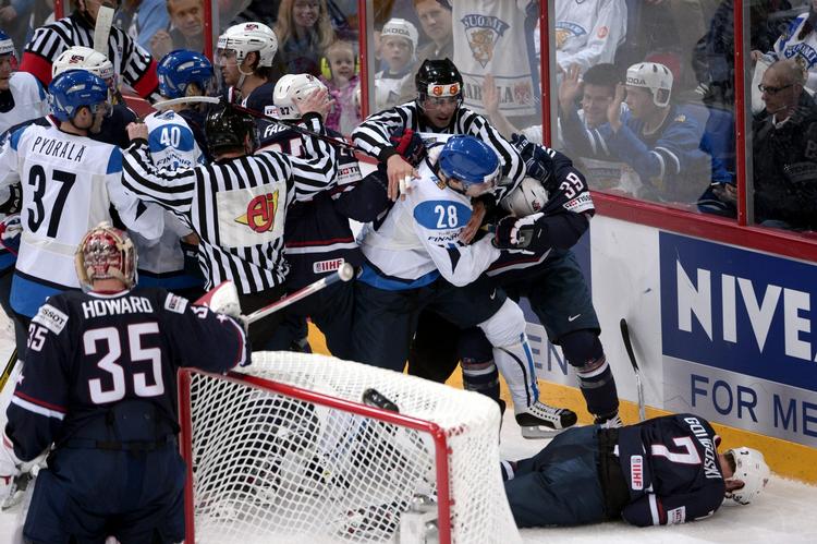 Overfald. Anssi Salmela (nr. 28 i hvid trøje) måtte værge for sig, da han brutalt havde hamret amerikanske Alex Goligoski (liggende) ind i banden ved VM i ishockey. 
