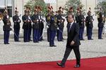 Præsidenter. Francois Hollande spadserer langs den røde løber på vej mod Nicolas Sarkozy, der skal overdrage ham posten som præsident i Frankrig. 