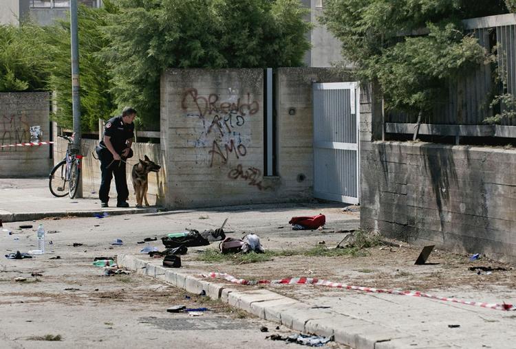 GERNINGSSTED. Betjent gennemser åstedet for bombeattentatet. Tilbage ligger skoletaskerne fra nogle af de unge, der blev kvæstede ved eksplosionen. 