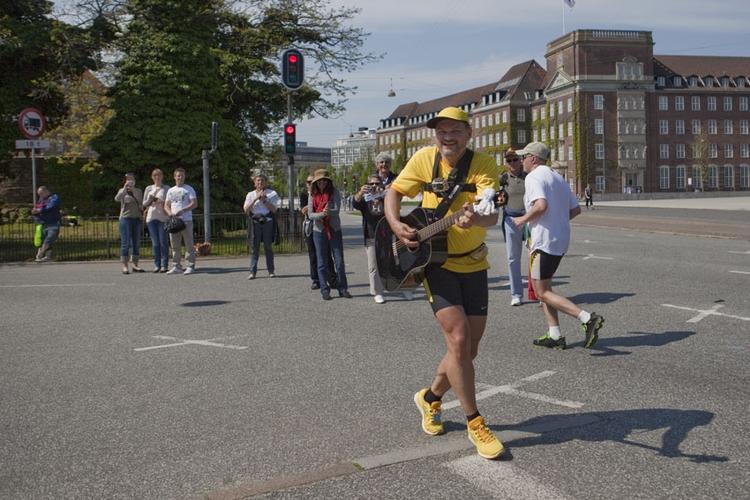 kræft. 54-årige Johnny Runner i det iøjenfaldende gule løbetøj og guitarremmen om nakken mener det alvorligt, når han løber for blandt andet Kræftens Bekæmpelse. 