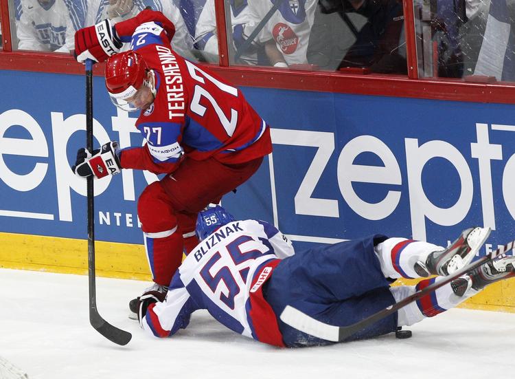 VM. En russisk spiller slås om pucken mod en slovakisk modstander. 