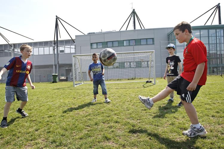 optakt. Drengene Marcus, Mads, Emil og Jiyan spiller på græsplænen foran Farum Park stadion. De glæder sig alle fire meget til mesterskabsfinalen. 