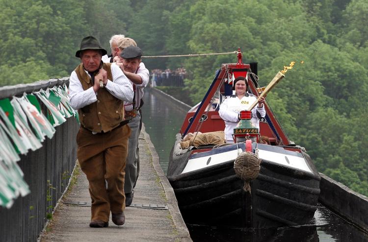 fakkel-fragt. OL-flammen var i dag nået til Pontcysyllte Aqueduct, som driftige mænd sørgede for at slæbe den over via båd. 