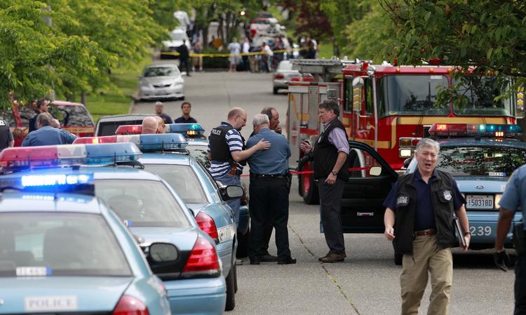 afspærret. Naboer ser til i baggrunden, mens politiet afspærrer det område, hvor den 40-årige mand har skudt sig selv, efter at have dræbt fire andre. 