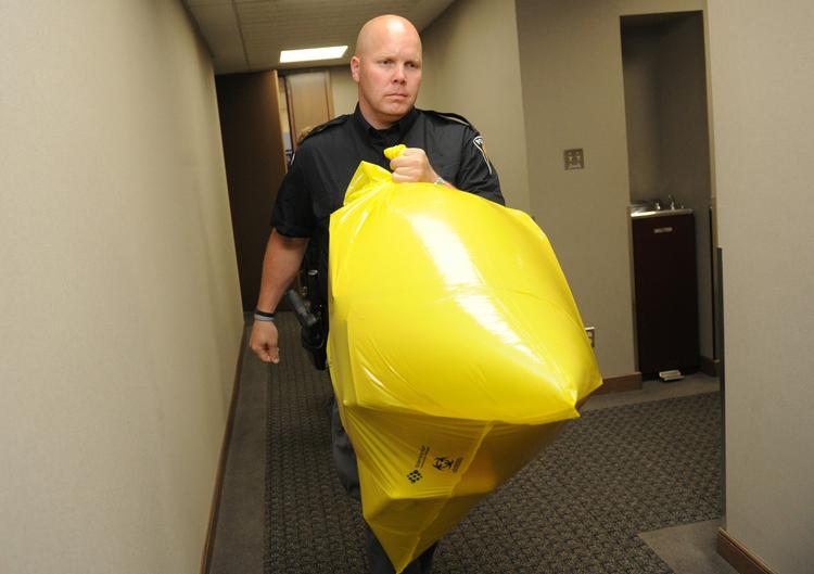 BEVISMATERIALE. Betjent fjerner postpakken med den afskårne fod fra partikontoret i Ottawa. 