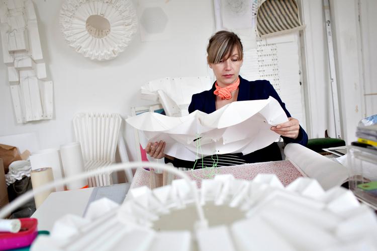 Foldedame. Amanda Betz har arbejdet med papir, siden hun blev færdig som arkitekt i 2005. Hun bruger blandt andet papir til at lave lamper. På væggen bagved hænger modellen til lampen Cassiopeia, som Le Klint har sat i produktion. 