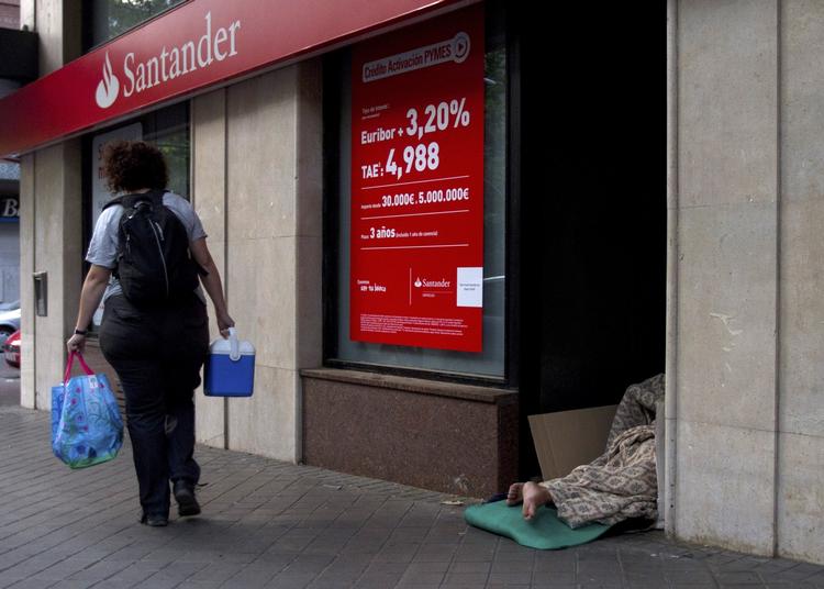 Nedtur. En hjemløs sover ved indgangen til den spanske bank Santander. Arbejdsløsheden i Spanien er på over 21 procent, og for den unge befolkning er den helt oppe på 44,6 procent. 