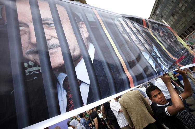 Udsigter. En egyptisk demonstrant holder et banner, der bl.a. viser præsident kandidat Ahmed Shafik bag tremmer. Men alternativet - Mohamed Morsi fra Det Muslimske Brodersakb - er heller ikke lyst. 