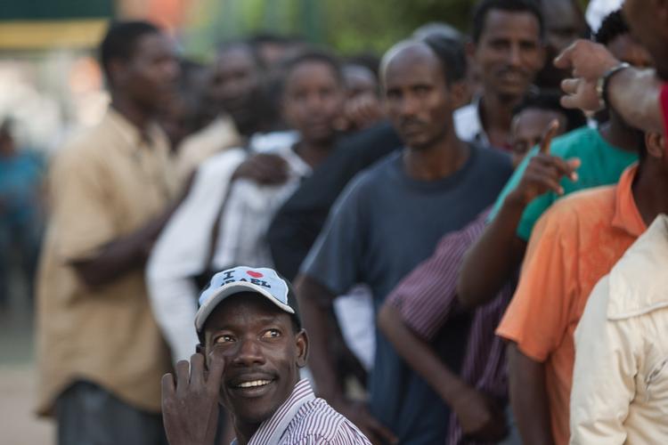 Udvist. Afrikanske migranter på vej til at blive deporteret står i kø for at få gratis mad i Tel Aviv, Israel. 