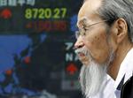 KURSER. Japaner foran kursskærm i Tokyo. De asiatiske børser steg fra morgenstunden på grund af det græske valgresultat. 