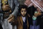 Flankeret af voksne - og knive. En lille dreng under en rituel ceremoni i Hajjah, Yemen, 1999. 