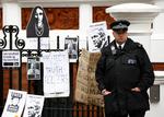 BEVOGTNING. Britisk 'bobby' foran Ecuadors ambassade, hvor tilhængere af Assange har hængt plakater til støtte for WikiLeaks' frontfigur. 