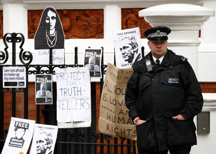 BEVOGTNING. Britisk 'bobby' foran Ecuadors ambassade, hvor tilhængere af Assange har hængt plakater til støtte for WikiLeaks' frontfigur. 