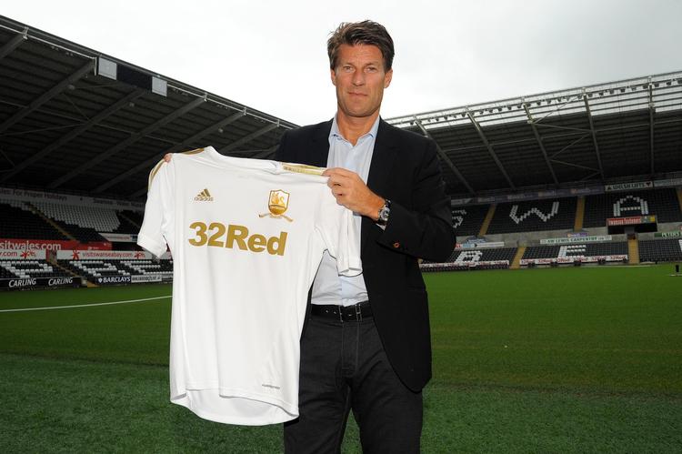 nyansat. Michael Laudrup viser sin nye Swansea-trøje frem under præsentationen af danskeren som ny træner i den walissiske klub. 