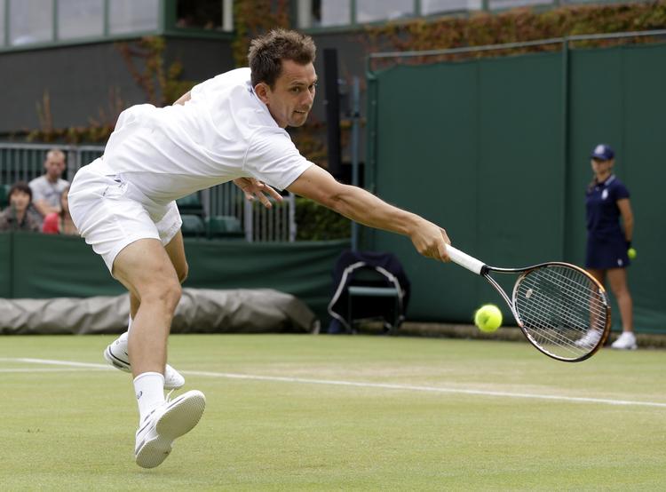 historisk. Frederik Løchte Nielsen returnerer en bold i ottendedelsfinalen ved Wimbledon. Danskeren slog til på den syvende matchbold i doublen med Jonathan Marray. 