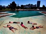 Børn ligger og bliver afkølet i det lave vand i et større bassin i Mud Island River Park i Memphis, Tennessee. 