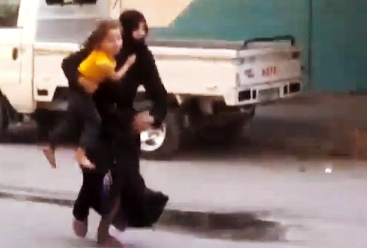 Løb. En uidentificeret kvinde flygter fra sit hjem i Damaskus. Billede fra en video formidlet af Ugarit News. Billedets autenticitet kan ikke bekræftes. 