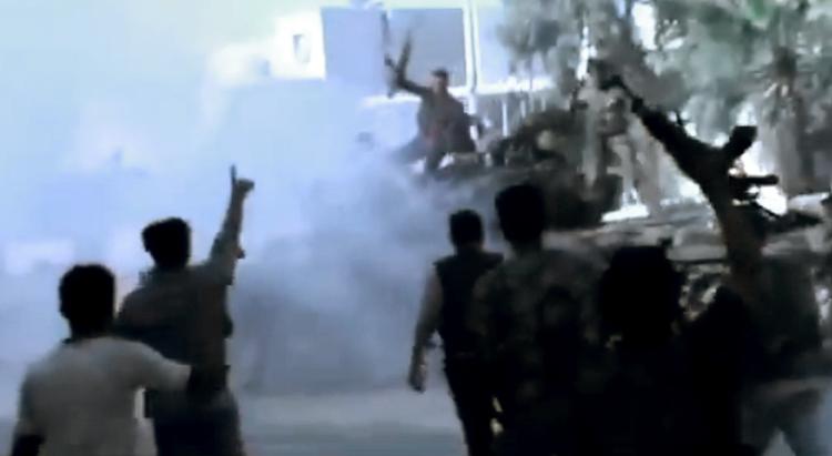 Jubel. Soldater fra oprørshæren jubler efter at have ødelagt to kampvogne fra regeringshæren. Billedet er angiveligt fra Aleppo i Syrien, men dets autenticitet kan ikke bekræftes. 