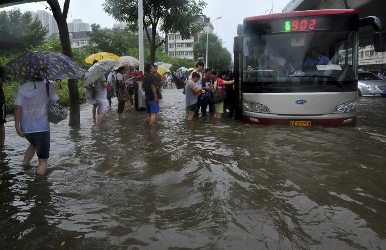 Oversvømmelser. Indbyggere i Tianjin forsøger at komme på en bus. 