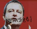 Ugyldig. En mand går forbi en valgplakat af Ivica Dacic. Plakaten er blevet overskrevet med ordet 'ugyldig'. 