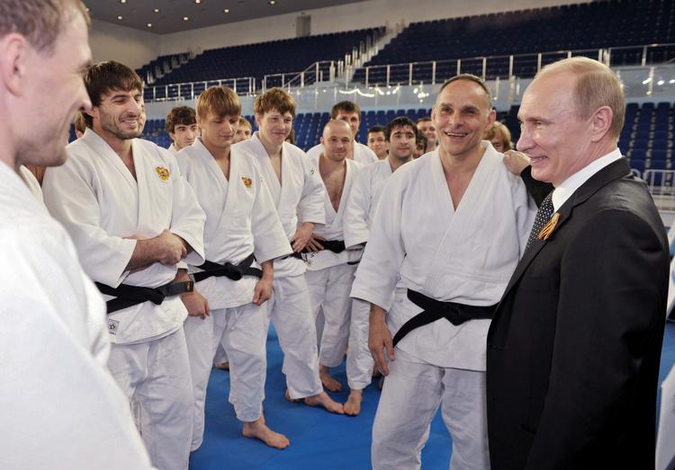 Putin. Hvad tænker brydere som Abdusalam Gadisov og Dshamal Otarsultanov, når de stiller op til tvekamp under det russiske flag ved OL i London, spørger Jarlner. Her ses Putin med brydere ved en tidligere lejlighed. 