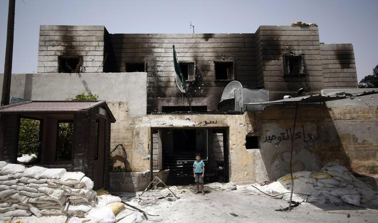RUIN. Dreng foran en ødelagt politistation i Azaz, 32 kilometer nord for Aleppo. Nu hævder oprørerne, at de har slået over 40 politimænd ihjel ved angreb på to stationer i den syriske millionby. 