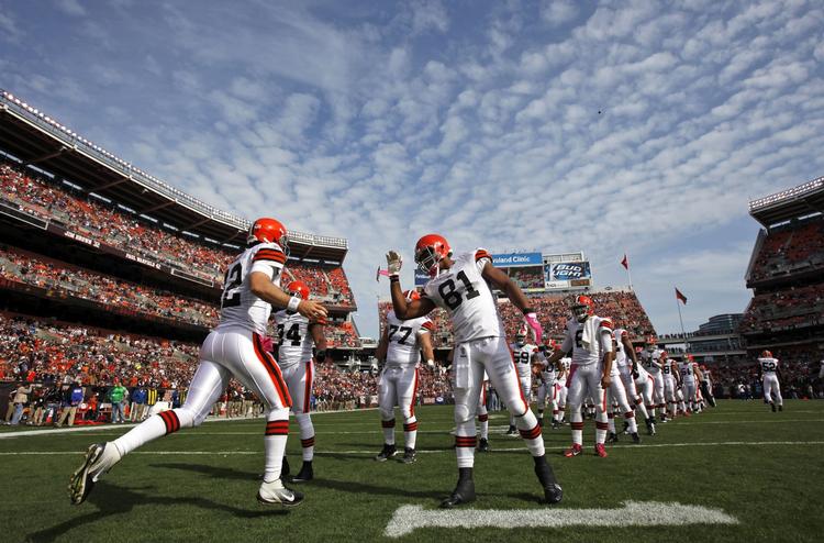 Haltende. Cleveland Browns quarterback Colt McCoy med nummer 12 bliver hyldet af sine holdkammerater inden en hjemmekamp mod Seattle Seahawks - en ud af blot fire kampe, som Browns vandt i den seneste sæson. 