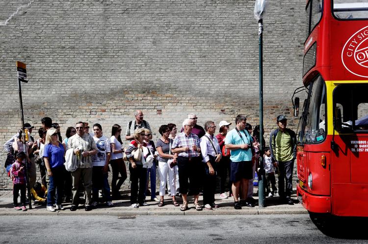kø. Turister i kø ved en sightseeingbus ved Amalienborg. Med en stigning på 12 procent om året er København en af Europas hurtigst voksende turistbyer.  Foto: Martin Bubandt 