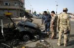 bilbombe. En række angreb har i dag ramt Irak. Her undersøger politibetjente stedet, hvor en bilbombe sprang i Kirkuk. 