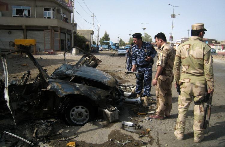 bilbombe. En række angreb har i dag ramt Irak. Her undersøger politibetjente stedet, hvor en bilbombe sprang i Kirkuk. 