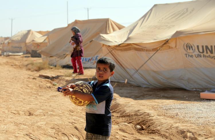 Flygtet. Mange syrere er flygtet til lejre i Jordan, hvor denne dreng kan glæde sig over at have fået en lille stykke legetøj i anledning af den muslimske højtid eid. 
