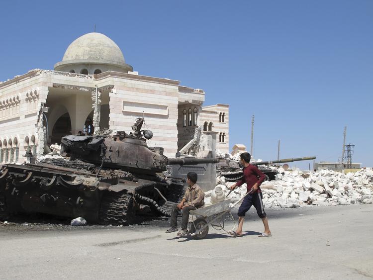 krigsbytte. Syriske drenge ved en ødelagt kampvogn i byen Azaz i går. 