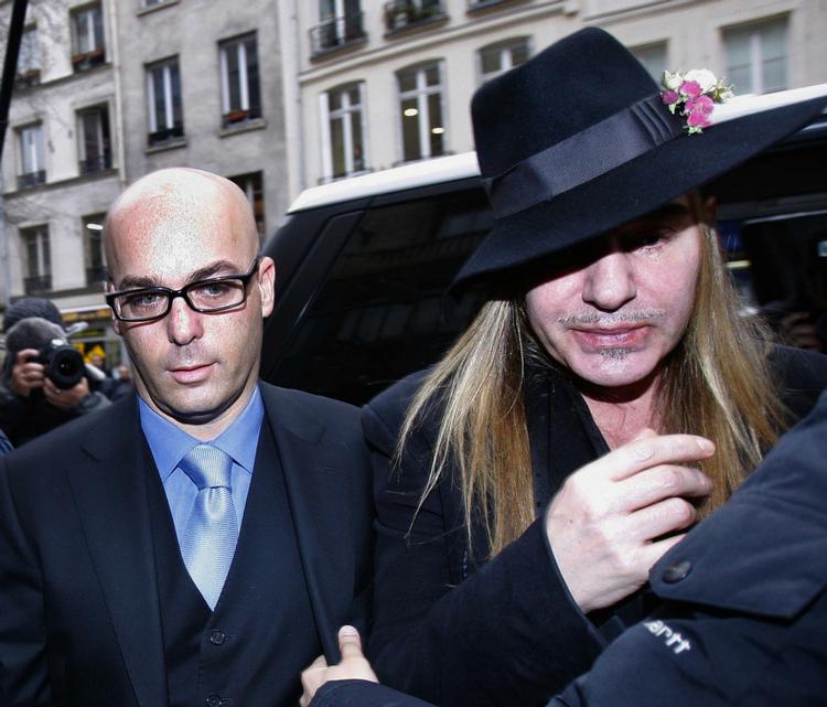 racist? Diors chefdesigner John Galliano (th) ankommer sammen emd sin advokat  til politistationen i Paris til afhøring i forbindelse med tre sager om påstået racisme. Den ene dokumenteret på video. 