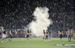 sammenstød. Græsk politi affyrer tåregas mod Paok Salonikis tilhængere, der stormede banen i et angreb på fans fra Rapid Wien under play-off-kamp. 