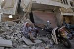 Murbrokker. To syriske mænd hviler ud ved en butik, der faldt sammen efter et angreb på et bageri i Azaz uden for Aleppo. 