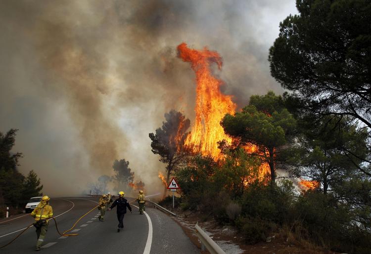ildkamp. Brandmænd arbejder på fuldt tryk for at få styr på flammerne ved Ojen i det sydlige Spanien. 