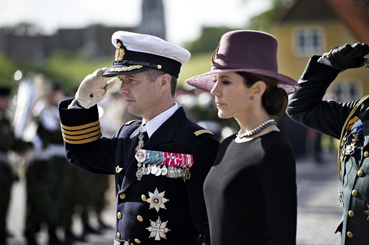 Andægtigt. Kronprinsen og kronprinsessen står ranke foran den krans, de netop har lagt ved en ceremoni til minde om danske soldater faldet i krigen. 