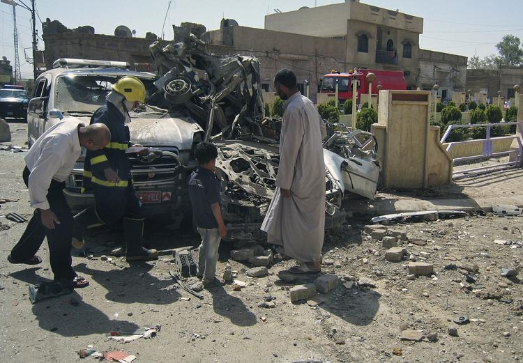 Kirkuk. Borgere og myndigheder inspicerer en smadret bil i det nordlige Irak. 