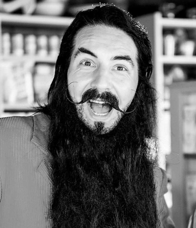 Skæg. Vært på DR's programmer 'Skæg med tal' og 'Skæg med bogstaver'. Bag det store skæg gemmer sig Mikkel Lomholt, der også har været med til at skrive sangene til programmerne. 