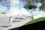 Oprør. Demonstranter udenfor den amerikanske ambassade i Tunis sender kasteskyts ind over muren. 