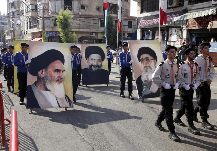 Hizbollah. Tilhængere af den militante gruppe på gaden i det sydlige Beirut, mens de bærer billeder af lederen, Sheik Nasrallah (arkiv). 