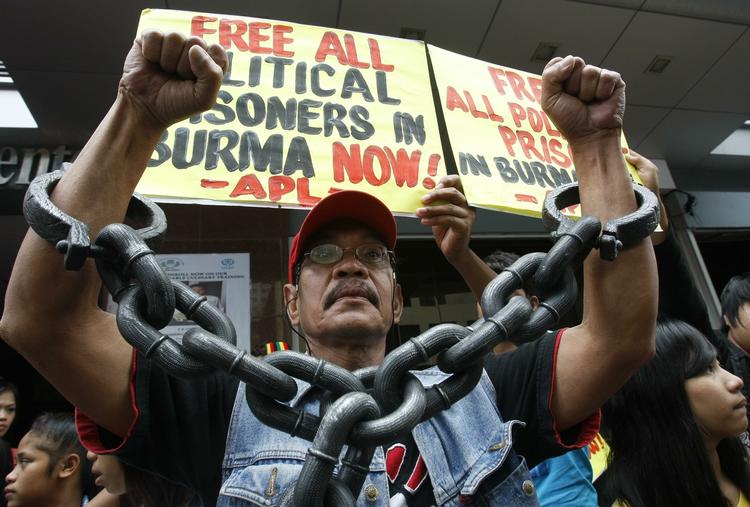 krav. 'Befri alle politiske fanger i Burma' står der på på skiltene bag manden i de store armlænker, og noget kan tyde på, at demonstranterne, der er fotograferet  Filippinernes hovedstad, Manila, tidligere på året, har fået det ønske opfyldt. 