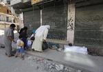 Borgerkrig. Endnu en dag - endnu flere dræbte. Forbipasserende kigger på tildækkede lig i millionbyen Aleppo. 
