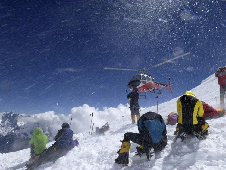redningsaktion. Ni bjergbestigere mistede livet på verdens 8. højeste bjerg i søndags. Billedet, der er fra samme dag, viser, hvordan overlevende bliver reddet af en helikopter. 