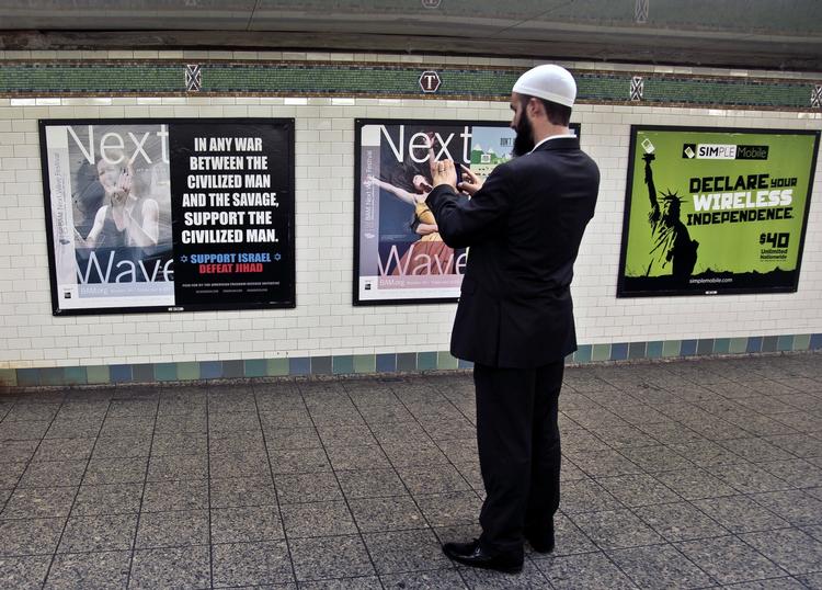 HADPLAKATER. Cyrus McGoldrick fra Rådet for Amerikansk-Islamiske Relationer (CAIR) tager et foto af en af de antiislamiske plakater på Times Square-stationen i det centrale New York. 