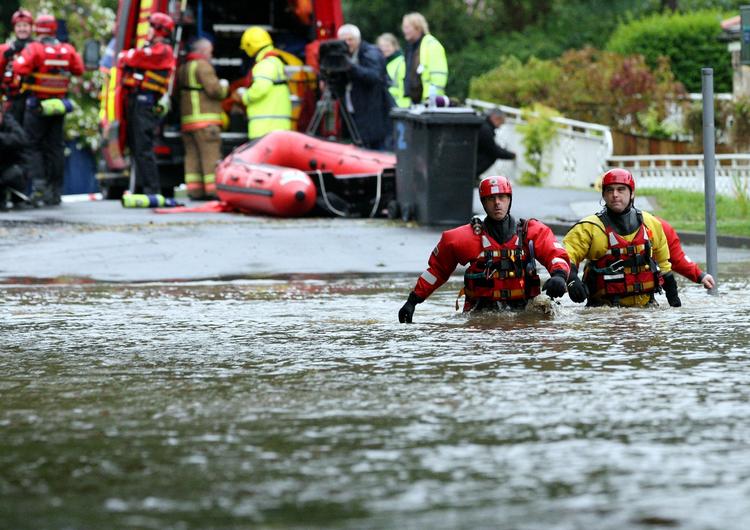 Oversvømmelse. Redningsarbejdere kæmper sig igennem vandmasserne efter at floden Wansbeck i dag gik over sine bredder i det nordøstlige England. 