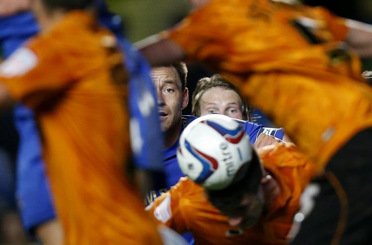 kaos. En Wolves-spiller header væk fra et hjørnespark, mens Chelseas John Terry (midt) kun kan se til. 