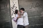 sorg. En syrisk mand (tv.) trøstes, efter at en snigskytte har dræbt hans bror i Syriens største by, Aleppo. 