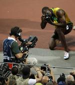 paparazzi. Usain Bolt (th) leger fotograf umiddelbart efter at have vundet OL-finalen på 200 meter i London. Nu er kameraet sat til salg. 